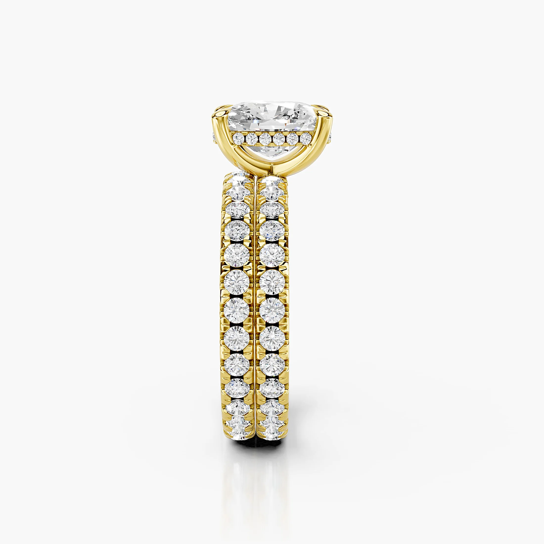 Cushion-shaped engagement ring with hidden halo, diamond-accented shoulders, and straight coordinating wedding band
